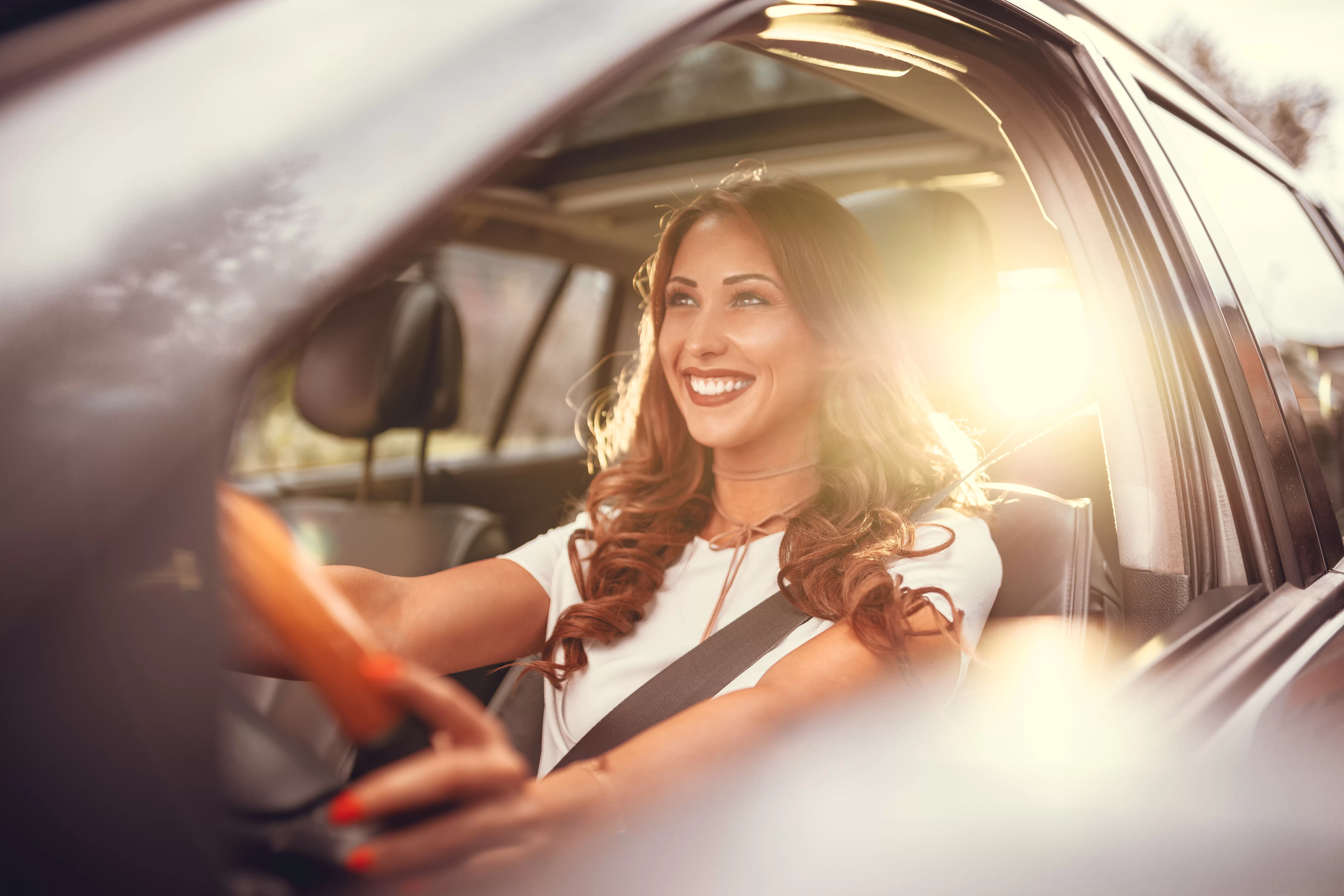 An excited young woman drives her new car after learning how much of a car loan she could afford.