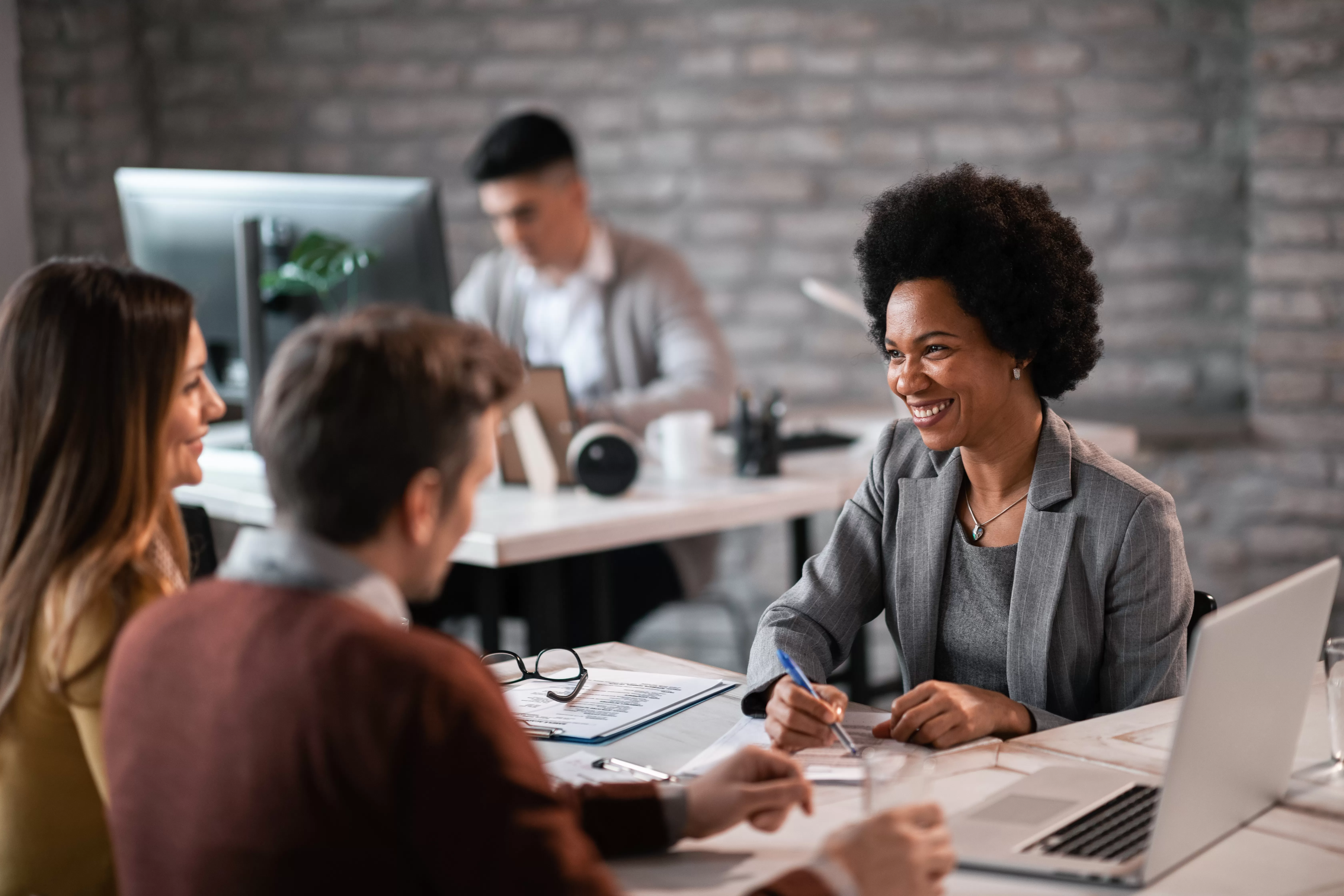 A couple meets with a credit union representative to discuss smart ways to manage an underwater car loan.