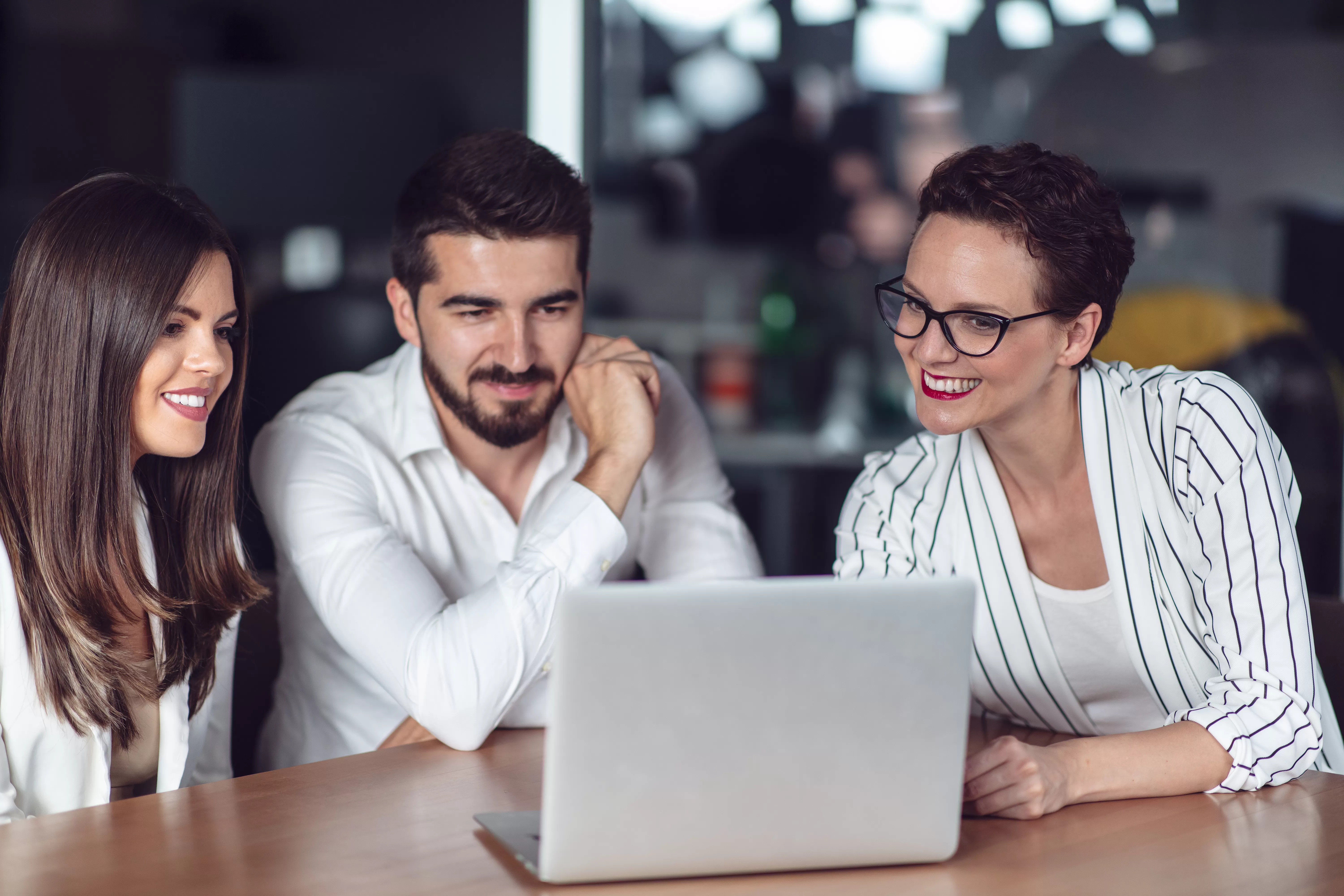 A young couple meets with a credit union representative to discuss auto loan amortization and getting on an auto loan amortization schedule.