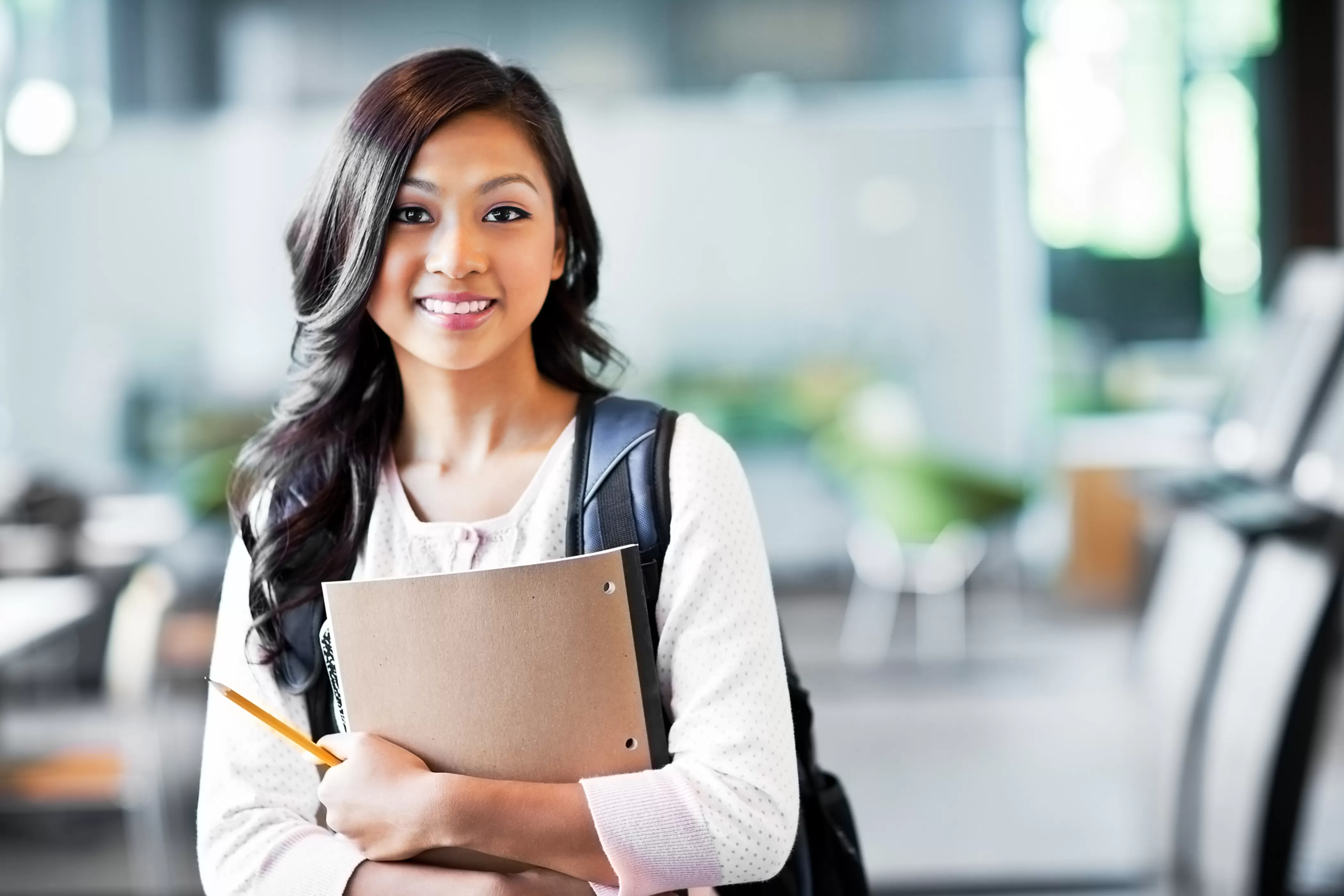 Teenage student holding a notebook