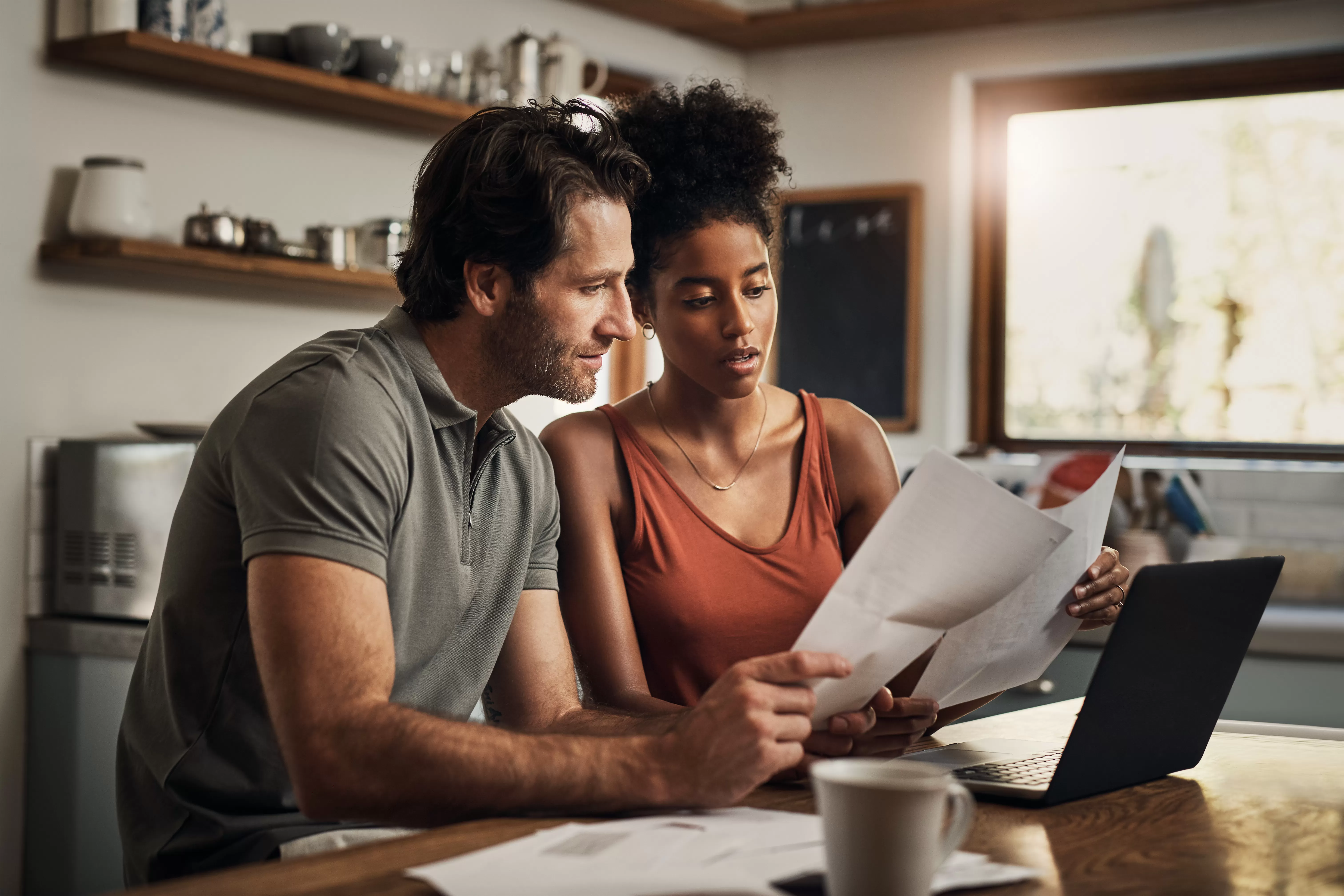 a couple works on their taxes and reviews documents to get a home equity loan interest tax deduction