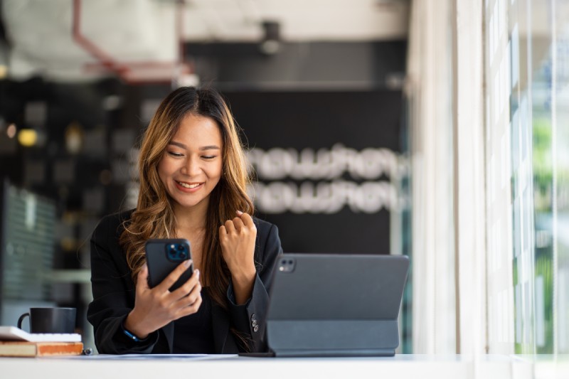 A business owner checks her online business checking account on her smartphone.
